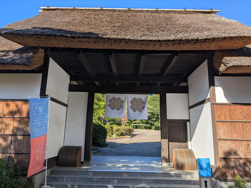 大倉公園の茅葺門に掛かる暖簾とバナー